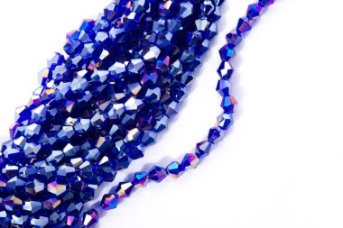 Güzel açık mavi cam parıltılı kristal boncuklar beyaz arka planda. Küçük boncuklu mücevherler için kullan