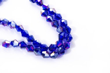 Güzel açık mavi cam parıltılı kristal boncuklar beyaz arka planda. Küçük boncuklu mücevherler için kullan