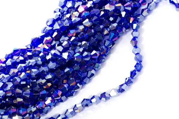Güzel açık mavi cam parıltılı kristal boncuklar beyaz arka planda. Küçük boncuklu mücevherler için kullan