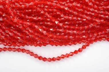Beyaz arka planda güzel kırmızı cam kristal boncuklar. Küçük boncuklu mücevherler için kullan