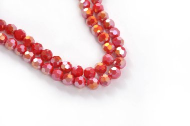 Beyaz arka planda güzel kırmızı cam kristal boncuklar. Küçük boncuklu mücevherler için kullan