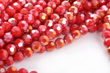 Beyaz arka planda güzel kırmızı cam kristal boncuklar. Küçük boncuklu mücevherler için kullan