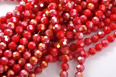 Beyaz arka planda güzel kırmızı cam kristal boncuklar. Küçük boncuklu mücevherler için kullan