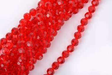 Beyaz arka planda güzel kırmızı cam kristal boncuklar. Küçük boncuklu mücevherler için kullan