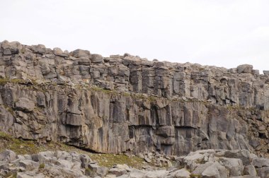 Karanlık ve ölü bazalt sütunları ve onlara yakın aşağıda çalışan bir nehir