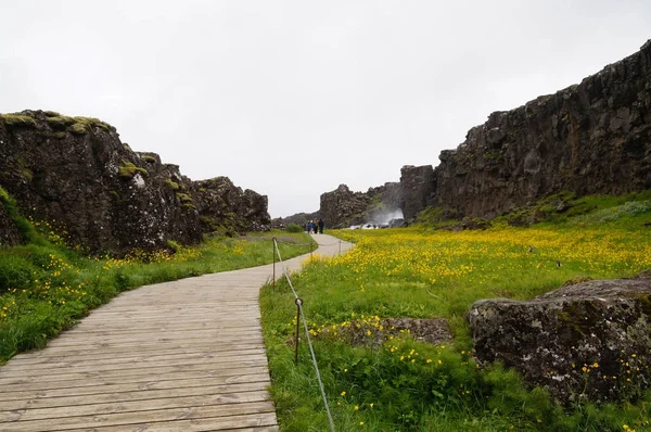 Tunnistamattomat turistit kävelemässä Thingvellirin kansallispuistossa, Islannissa . — kuvapankkivalokuva
