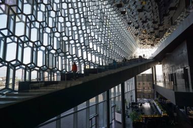 Kimliği belirsiz turist Harpa konser salonu ve konferans merkezi Reykjavik, İzlanda yürüyüş.