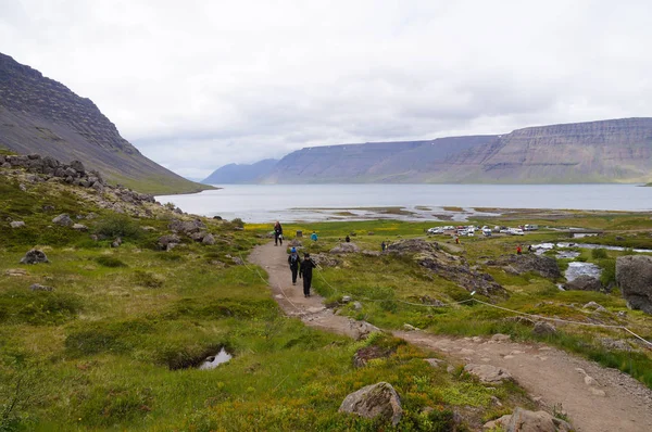 Turistas no identificados caminando a la cascada de Dynjandi, Islandia . — Foto de Stock