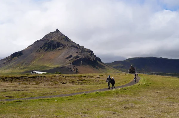 Turistas no identificados caminando cerca de la Estatua de Bardur Snaefellsnes, Islandia . — Foto de Stock