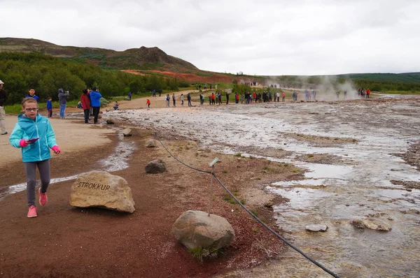 Unidentified girl walking by Strokkur Geysir in Iceland — Stock Photo, Image