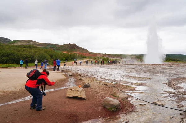 Unidentified tourist taking picture of Strokkur Geysir in Iceland — Stock Photo, Image