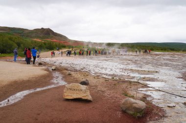 kimliği belirsiz turist Strokkur Geysir İzlanda'daki patlama bekliyor.