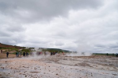 kimliği belirsiz turist Strokkur Geysir İzlanda'daki patlama bekliyor.