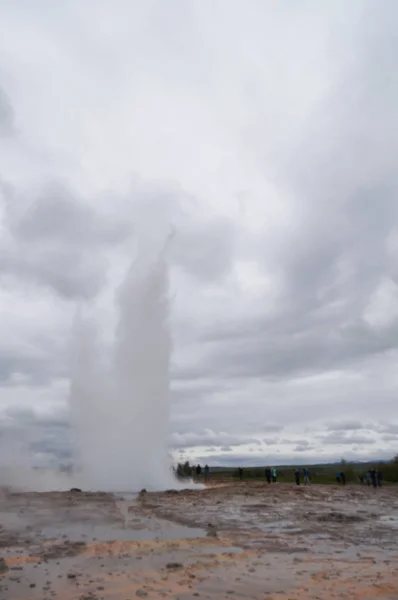 Unidentified tourists waiting for eruption of Strokkur Geysir in Iceland. — Stock Photo, Image