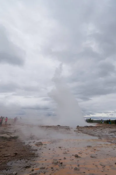 Unidentified tourists waiting for eruption of Strokkur Geysir in Iceland. — Stock Photo, Image