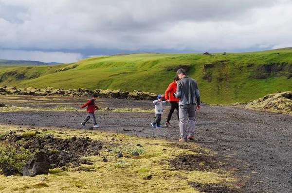 Turistas no identificados caminando para ver el campo de lava cubierto de gre — Foto de Stock