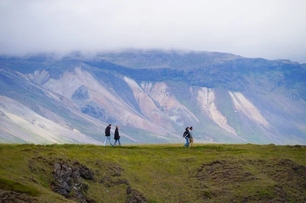 Neznámých turistů chůzi vidět Gatklettur kamenný oblouk, Island. — Stock fotografie