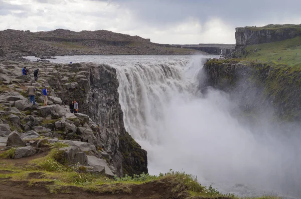 正体不明の観光客がアイスランドの Dettifoss で写真を撮る. — ストック写真