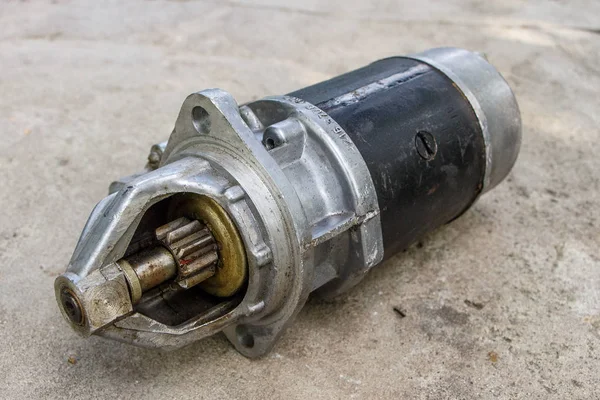 Old car starter on concrete surface