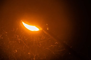 Bir fenerden gelen sarı ışık düşen karı aydınlatır.