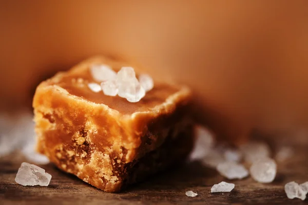 Karamell-Bonbons auf braunem Hintergrund — Stockfoto