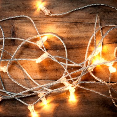 Ahşap arka plan üzerinde Noel ışıkları.