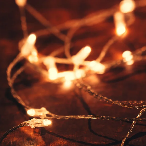 Christmas lights over wooden background. — Stock Photo, Image