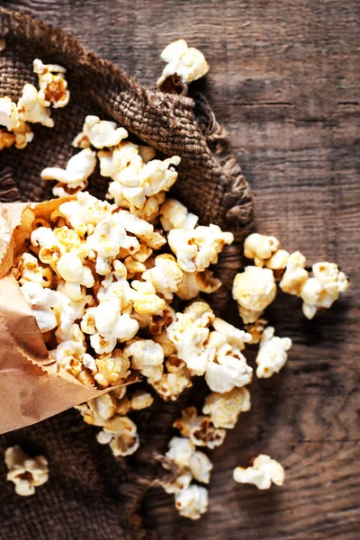 Popcorn in einer Tüte auf Holzgrund — Stockfoto