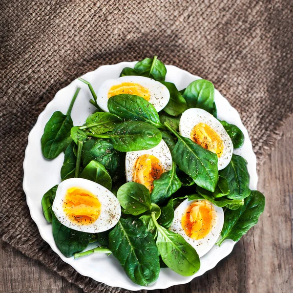 Frische Spinatblätter und gekochte Eier — Stockfoto