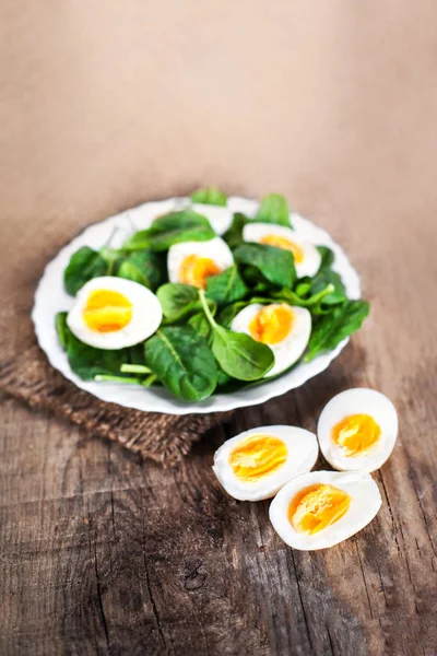 Spinach leaves and boiled eggs — Stock Photo, Image