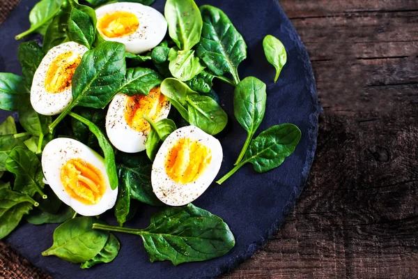 Frische grüne Spinatblätter und gekochte Eier — Stockfoto