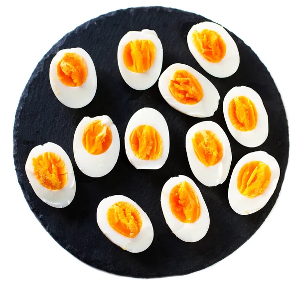 Halved Eggs on black plate — Stock Photo, Image