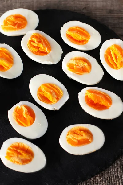 Halved  Eggs on wooden black — Stock Photo, Image