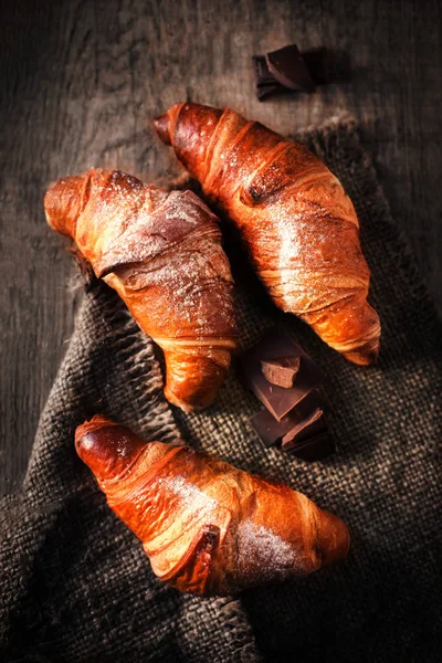 Leckere frische Croissants auf einem dunklen — Stockfoto