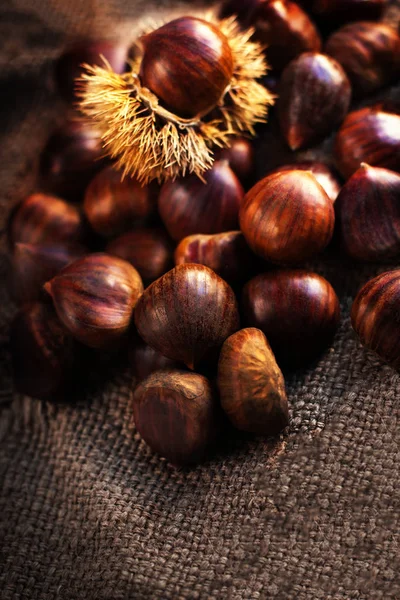 Ripe chestnuts on old wooden table — Stock Photo, Image