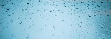 Mavi cam arka plan üzerinde yağmur damlaları. Yağmur damlaları doğal deseni. Şehrin bir windo su yağmur