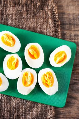 Katı pişmiş yumurta, dilimlenmiş devrede kesme tahtası ahşap arka plan yakın u