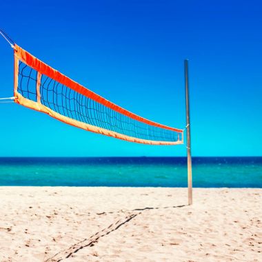 Voleybol net ve boş plaj. Deniz plaj ve yumuşak mavi okyanus dalgası. Yaz günü ve kum arka plan.