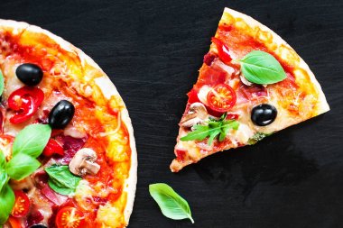 Koyu arka plan üzerinde jambon, domates ve peynirli pizza. Bir pizzacı veya restoran Sucuklu sosisli sıcak pizza servis