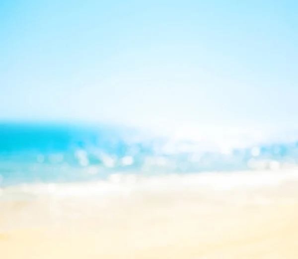 Blur summer white tropical sand beach with sparkling sea water. Blurred relaxing outdoors vacation  bokeh background, travel concept. Copy space