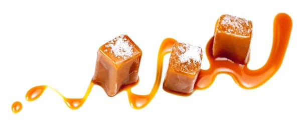 Beyaz arka plan üzerinde izole ev yapımı tuzlu karamel parçalar. Altın karamela toffee şeker karamel makro