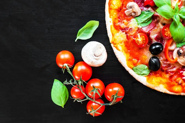 Koyu arka plan üzerinde jambon, domates ve peynirli pizza. Bir pizzacı veya restoran Sucuklu sosisli sıcak pizza servis