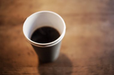 Siyah kahve Americano ahşap masa vintage hippi tarzı renk tonu bir kağıt bardak