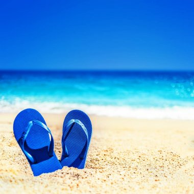 Yaz tatil plaj arka flip ile tropikal bir kumsalda floplar. Bir kum bir plajda, komik kavramı üzerinden terlik