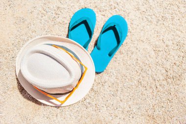 Yaz tatil plaj ve arka plan flip flop bir tropikal plaj şapka. Terlik boşaltmak kumla üzerinde