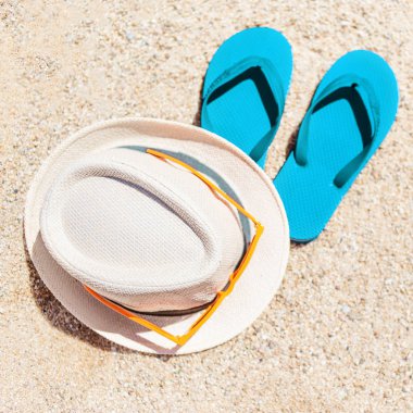 Yaz tatil plaj ve arka plan flip flop bir tropikal plaj şapka. Terlik boşaltmak kumla üzerinde