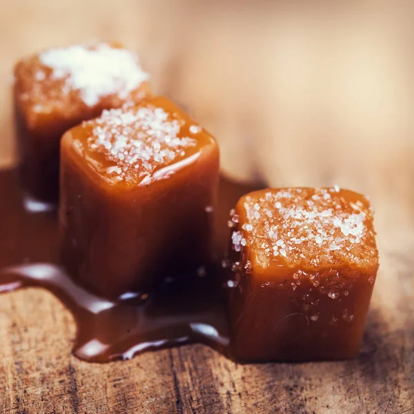 Saltade Karamell Godis Och Kolasås Trä Bakgrund Gyllene Kola Toffee — Stockfoto