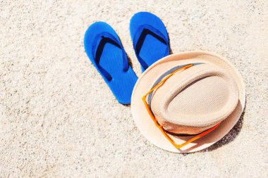 Sarı kum üzerinde mavi sandalet terlik. Yaz eğlenceli zaman ve aksesuarları sahilde, yaz tatillerini, kopyalama alanı