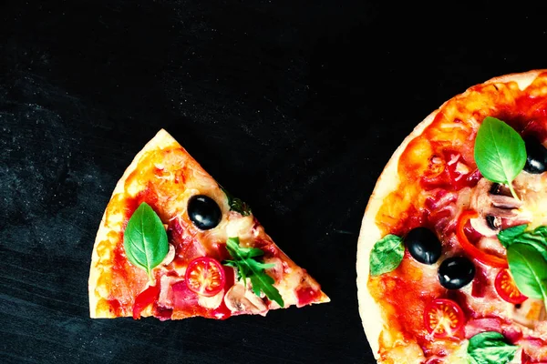 暗い背景にハム トマト チーズのピザ ピッツェリアやレストランで提供していますホット ペパロニ ソーセージのピッツァ — ストック写真