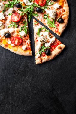 Sıcak pizza dilim eritilmiş mozzarella peyniri ve domates siyah beton zemin üzerine. Pizza hazır yemek için boşaltmak